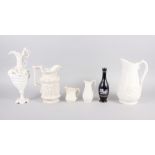 A Meigh Silenus jug, 7 1/2" high, four other relief decorated jugs, and a black glazed vase with