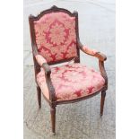A 19th century French carved walnut open armchair of Louis XVI design, upholstered in a floral