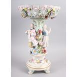 A Continental porcelain table centre, the stem decorated with two figures and floral decoration to