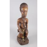 A West African carved hardwood seated ancestor figure, 25" high