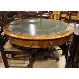 A Victorian figured walnut circular drum top table with green tooled leather lining over four