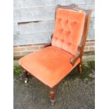 An Edwardian carved walnut showframe low seat occasional chair, upholstered in an orange velour,