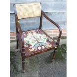 A mahogany carver dining chair of Regency design with caned panel back and needlepoint drop-in seat,