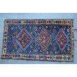 A Qashqai rug with three medallions on a blue ground with birds, flowers and trees, 27 1/2" x 50 1/