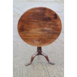 A Georgian mahogany circular tilt top occasional table with birdcage and barrel turned column, on