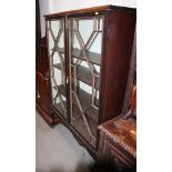 A mahogany display cabinet enclosed astragal glazed doors, on cabriole supports, 42" wide x 14" deep