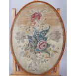 A 19th century silk embroidery of flowers, 16 3/4" x 12", in an oval string inlaid frame (losses)