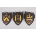 Three ebonised plaques with coat of arms decoration, 8" high