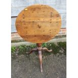 A provincial oak circular tilt top occasional table, on baluster turned column and tripod splay