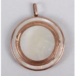 A mother-of-pearl circular pendant compact with yellow metal mounts, stamped 9ct, 2" dia (cracks
