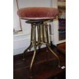 An early 20th century brass framed piano stool with adjustable seat