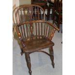 An early 19th century ash and elm panel Windsor splat back elbow chair, on turned supports with
