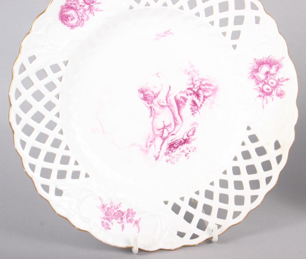 A pair of bone china plates with puce cherub and floral decoration with pierced borders, 9 1/2" dia