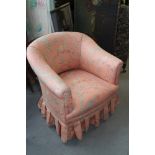 An Edwardian polished as walnut tub-shape armchair, upholstered in a pink floral fabric, on square