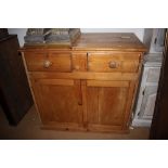 A waxed pine side cabinet, fitted two drawers over two doors, on block base, 14 1/2" wide x 21" deep