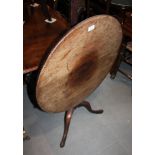 A 19th century mahogany circular tilt top low occasional table, on turned column and tripod splay