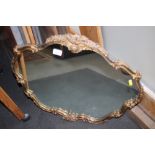 A floral and gilt decorated shape frame wall mirror, plate 16" x 24" overall