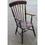 A farmhouse spindle back elbow chair with panel seat, on turned and stretchered supports
