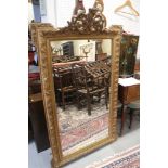 A gilt framed wall mirror with pierced cresting, on moulded frame plate, 25 1/2" x 47"