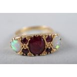 An 18ct gold dress ring set central ruby and two opals