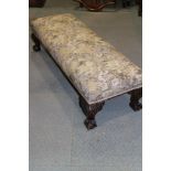A fender stool with tapestry seat, on cabriole claw and ball supports, 48" long