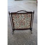 An early 20th century mahogany framed firescreen with needlework panel, on splay supports, 30"