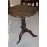 A late Georgian oak provincial circular top occasional table, on turned column and tripod splay