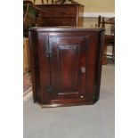 A late Georgian oak corner hanging cupboard enclosed panel door with original green painted interior