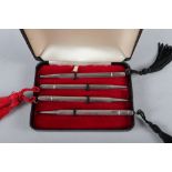 A set of four sterling silver bridge pencils with engine turned decoration, in fitted case