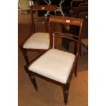 A pair of Regency carved rosewood bar back dining chairs with drop-in seats, on turned supports