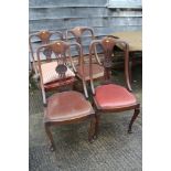 A set of four Edwardian walnut pierced shaped splat back dining chairs with drop-in seats, on