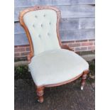 A pair of "lady's and gentleman's" Victorian carved walnut showframe chairs, upholstered in a sage