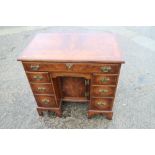 A figured walnut and banded kneehole desk of George I design, fitted one long drawer over six
