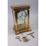 A Rapport brass four-glass clock with white enamel dial and Roman numerals, 11 1/2" high