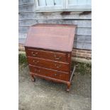 An oak bureau with three graduated drawers, on claw and ball supports, 28 1/2" wide