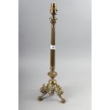 A 19th century brass candlestick, now converted as a table lamp, on tripod and lion paw feet, 20 1/