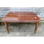 A late 19th century mahogany dining table with two extra leaves, on turned and tapering supports,