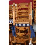 A set of eight pine ladder back dining chairs with rush envelope seats, on turned and stretchered
