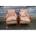A pair of polished as walnut French Regency design showframe armchairs, upholstered in a striped