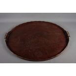 A mahogany oval galleried tray with brass handles, 28" wide