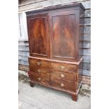 A late Georgian figured mahogany linen press, the upper section enclosed two doors over two short