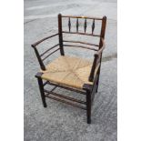 A late 19th century Sussex elbow chair with rush envelope seat, on turned and stretchered supports