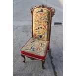 A late Victorian carved rosewood showframe prie dieu/nursing chair with Pugin style needlepoint seat