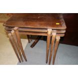 A nest of three walnut occasional tables, on turned and stretchered supports, 18"wide x 13" deep x