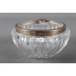 A cut glass circular ashtray with silver rim