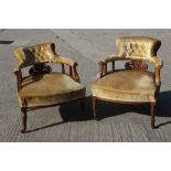 A pair of Edwardian rosewood and inlaid tub-shape low seat armchairs, on turned and castored