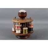 A mahogany revolving bobbin stand with pin cushion, 7 1/2" high