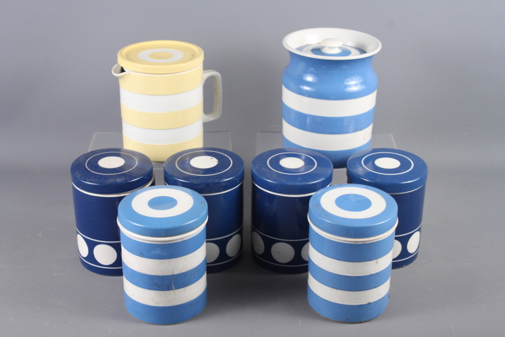 Seven Cornishware blue and white storage jars, and a yellow and white Cornishware jug and cover,