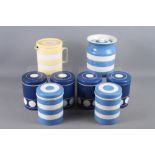 Seven Cornishware blue and white storage jars, and a yellow and white Cornishware jug and cover,