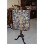 A 19th century mahogany pole screen with gros point panel of vase of flowers, on turned column and